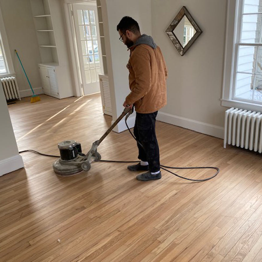 man sanding hardwood floor